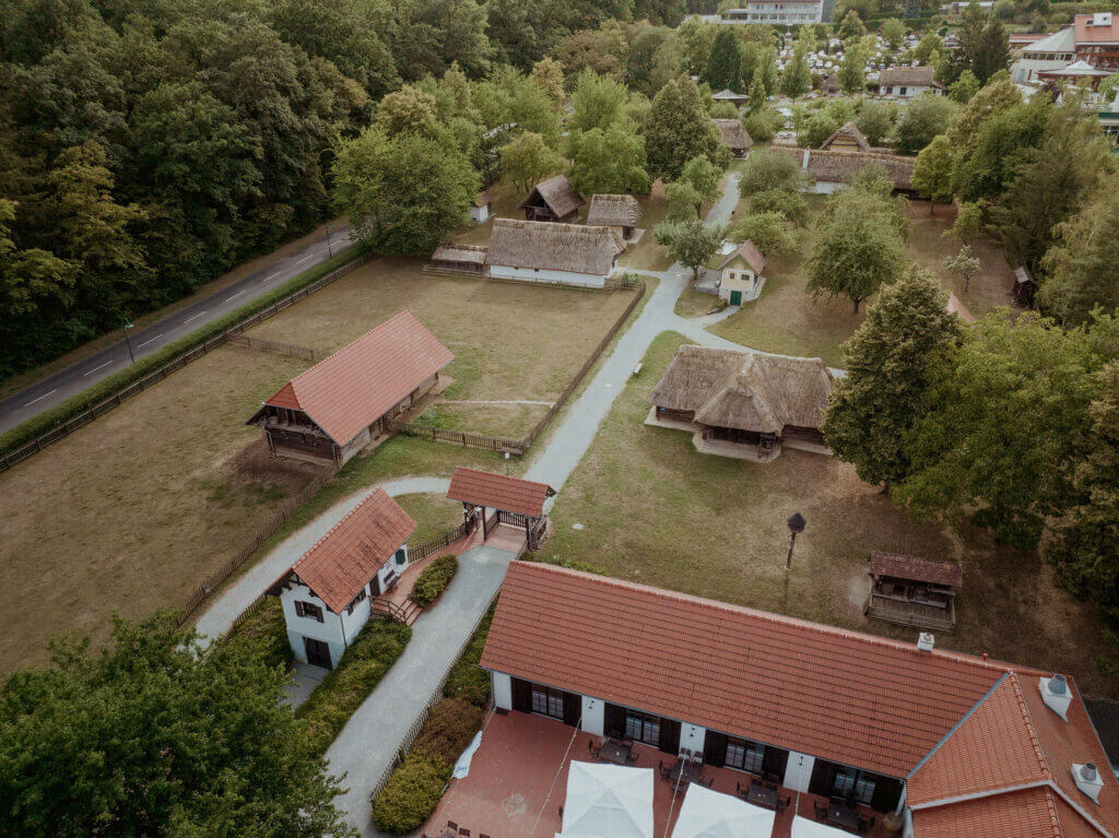 Das Freilichtmuseum in Bad Tatzmannsdorf von oben betrachtet. Man sieht die alten strohgedeckten Häuser und auch den Arkadenheurigen