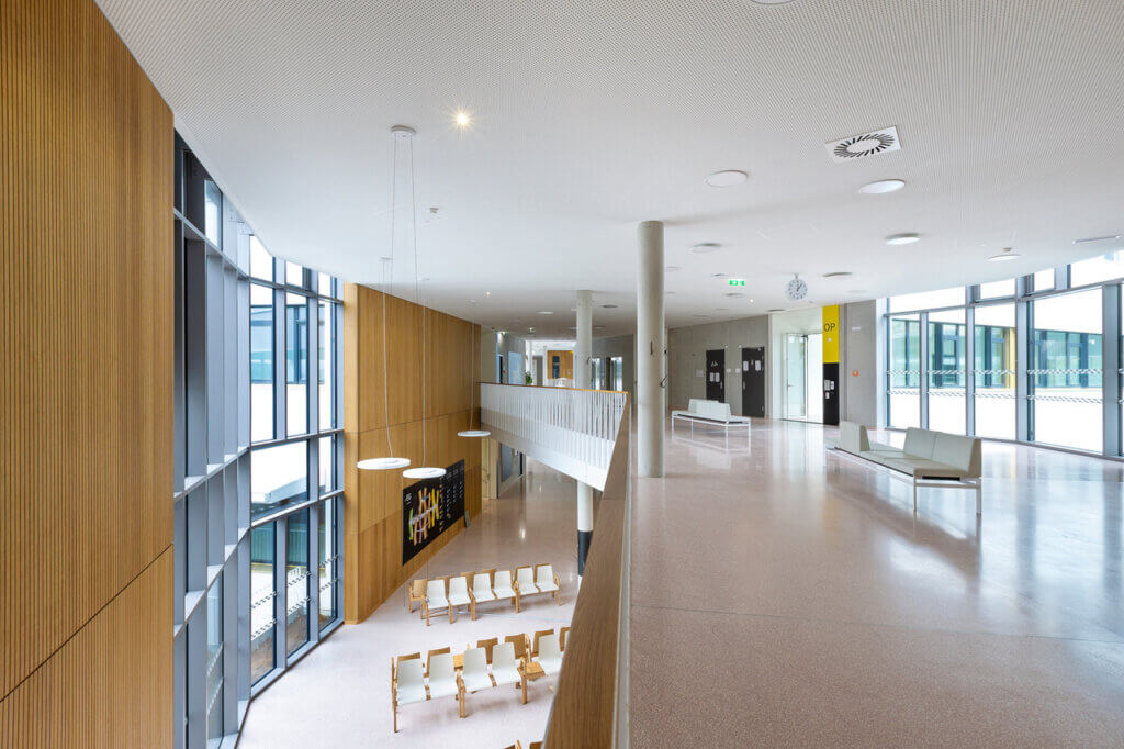 Ein Foto aus dem zweiten Stock der neuen Klinik Oberwart bietet Blick auf beide Stockwerke. Große Fenster und helle Einrichtung sorgen für viel Licht und eine warme Atmosphäre.